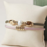 Pulsera para mujer con piezas doradas bañadas en oro con seda elástica
