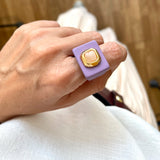 Foto detalle de anillo color malva con piedra natural de cuarzo rosa puesto en la mano.